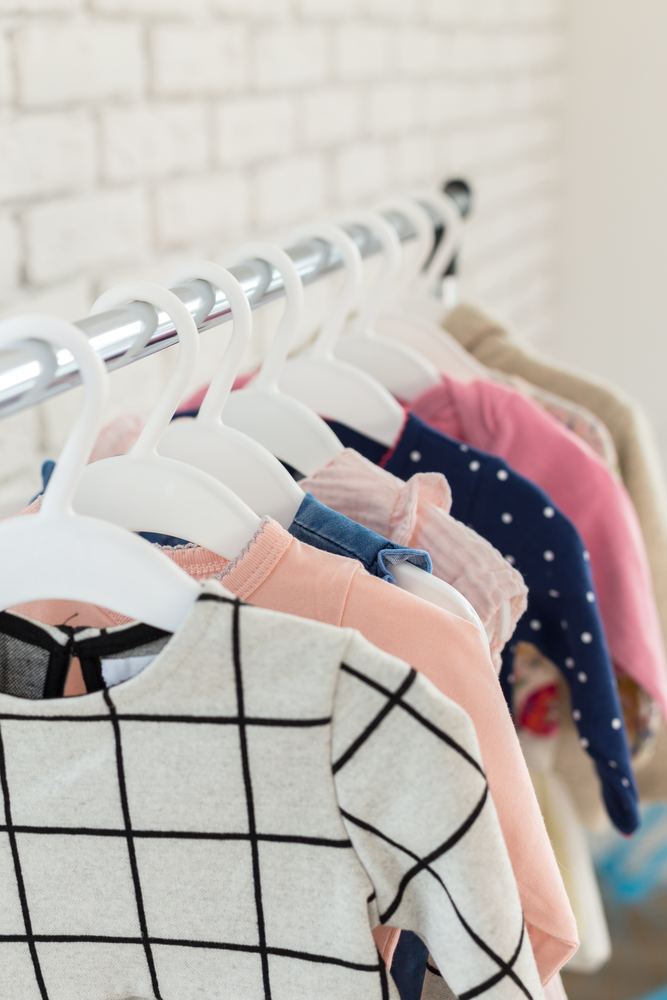 Clean children's clothes on white hangers
